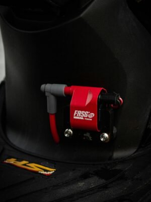 Detailed shot of a red FASS fuel system component mounted on a black surface.