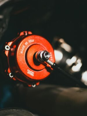 Detailed view of a red valve in a car engine, highlighting precision engineering.