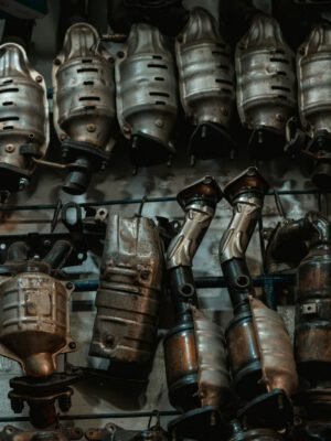 Rows of used catalytic converters in an automotive workshop setting.